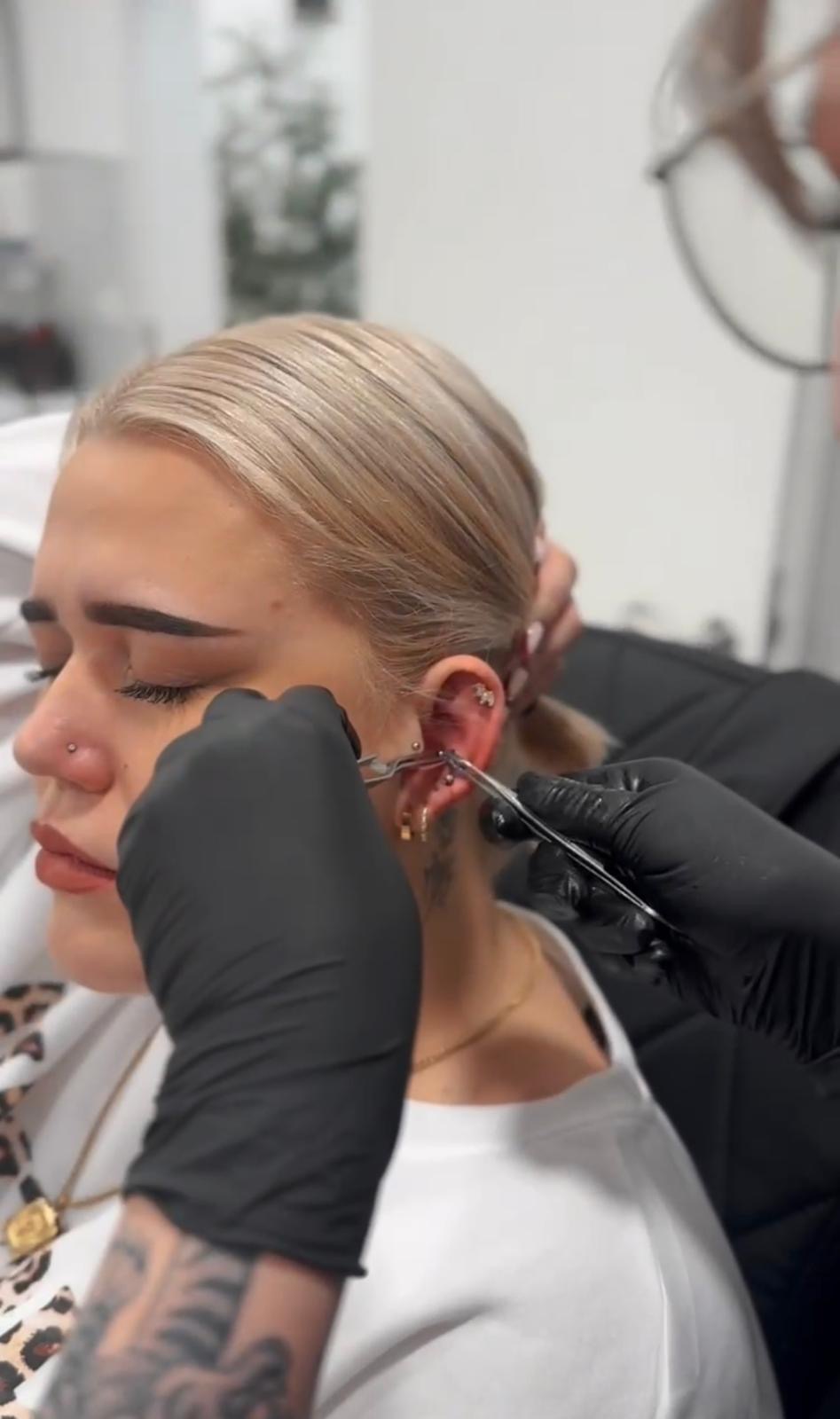 Alessa beim präzisen Stechen eines Helix-Piercings
